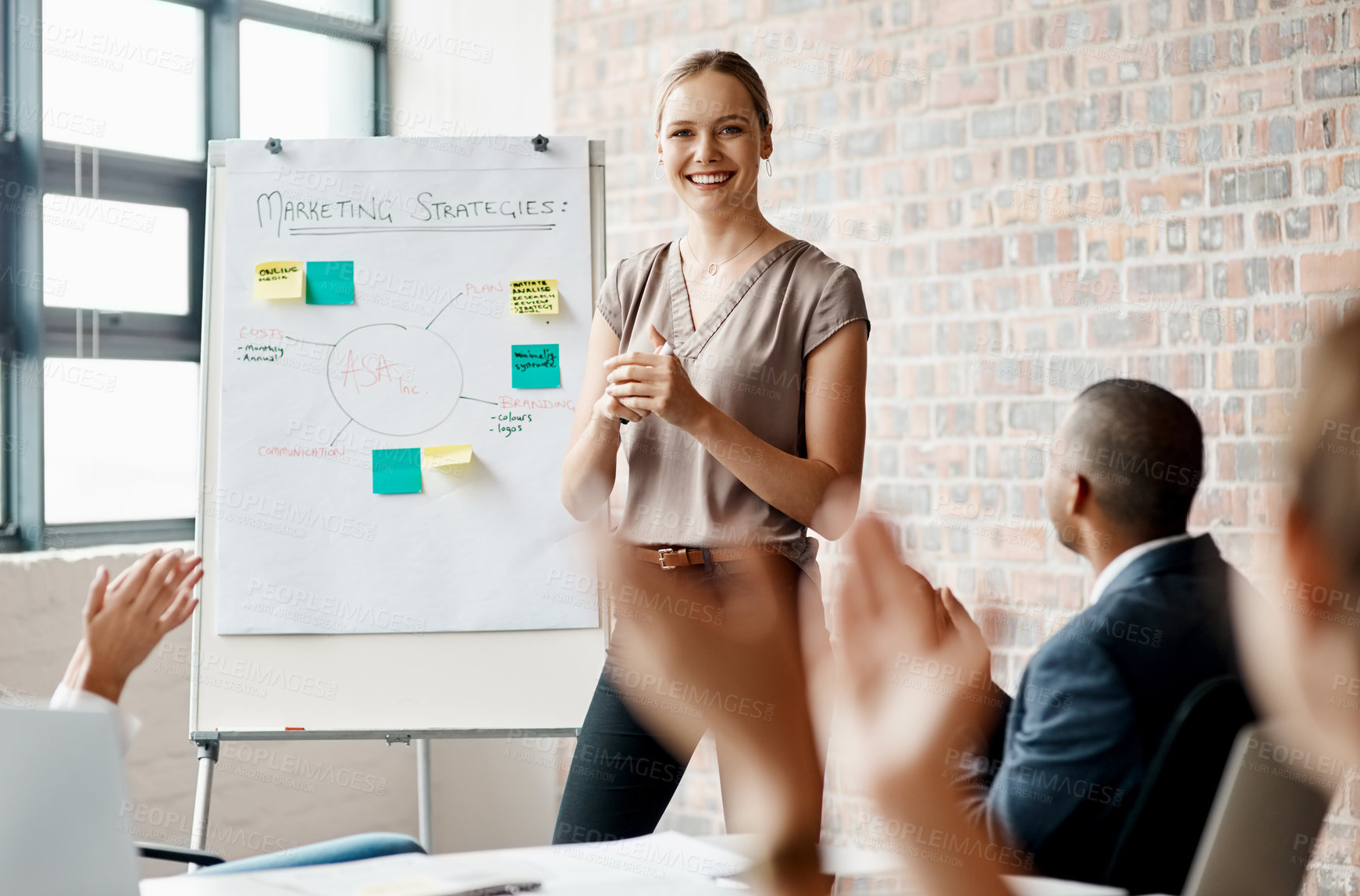 Buy stock photo Shot of a young businesswoman receiving applause during a presentation in an office