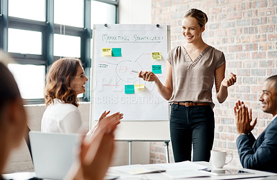 Buy stock photo Shot of a young businesswoman receiving applause during a presentation in an office