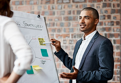 Buy stock photo Shot of a young businessman presenting notes on a whiteboard in an office