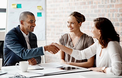 Buy stock photo Shot of businesspeople shaking hands in an office