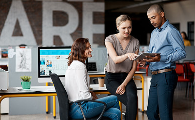Buy stock photo Shot of a group of businesspeople using a digital tablet together in an office