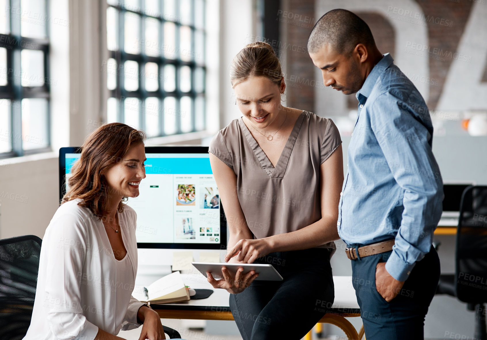 Buy stock photo Shot of a group of businesspeople using a digital tablet together in an office