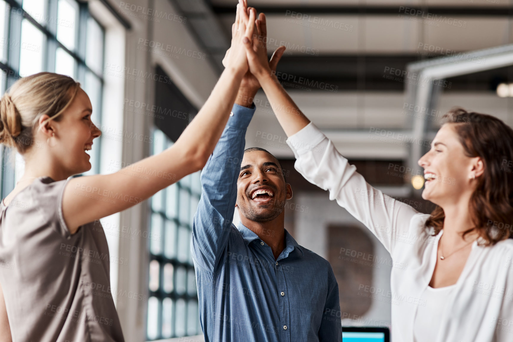 Buy stock photo Shot of a group of businesspeople giving each other a high five in an office