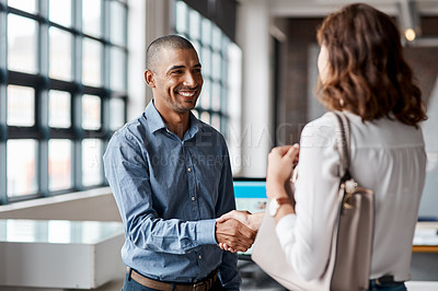 Buy stock photo Shot of a young businessman shaking hands with a woman in an office