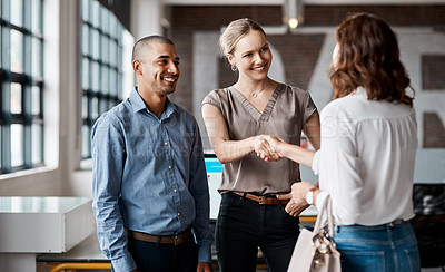 Buy stock photo Shot of businesspeople shaking hands in an office