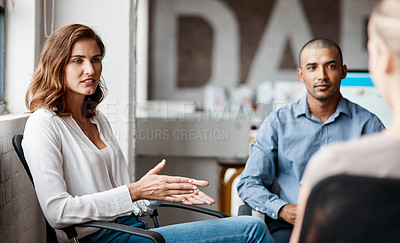 Buy stock photo Shot of a young businesswoman having a discussion with her colleagues in an office