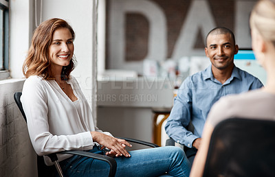 Buy stock photo Shot of a young businesswoman having a discussion with her colleagues in an office