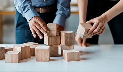 Buy stock photo Closeup shot of a group of unrecognisable businesspeople stacking building blocks together in an office
