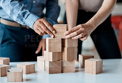 Buy stock photo Closeup shot of a group of unrecognisable businesspeople stacking building blocks together in an office
