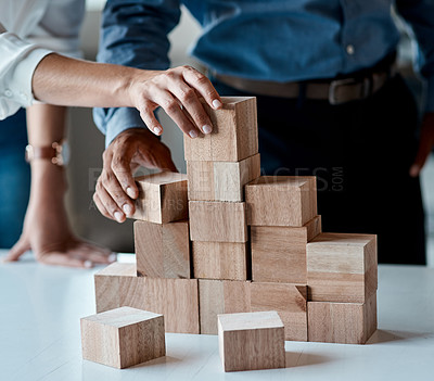 Buy stock photo Closeup shot of a group of unrecognisable businesspeople stacking building blocks together in an office