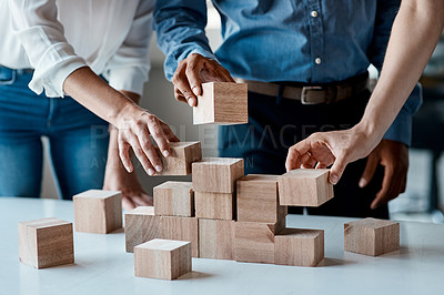 Buy stock photo Closeup shot of a group of unrecognisable businesspeople stacking building blocks together in an office