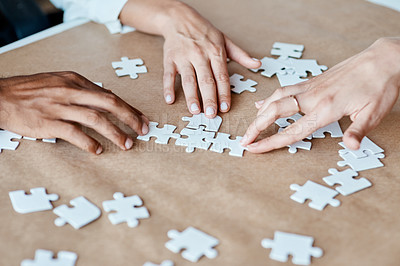 Buy stock photo Closeup shot of a group of unrecognisable businesspeople joining puzzle pieces together in an office