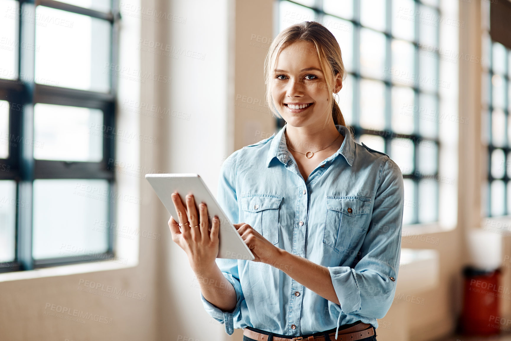 Buy stock photo Portrait of a young businesswoman using a digital tablet in a modern office