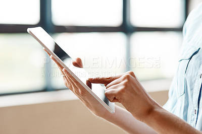 Buy stock photo Shot of an unrecognisable businesswoman using a digital tablet in a modern office