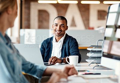 Buy stock photo Shot of a young businessman having a discussion with his colleague in a modern office