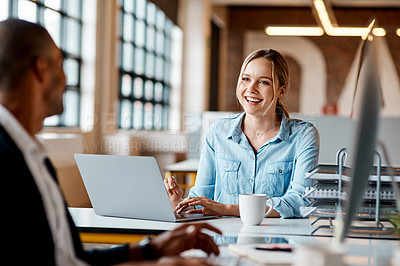 Buy stock photo Shot of a young businesswoman having a discussion with her colleague in a modern office