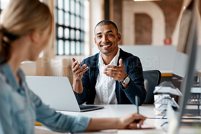 Buy stock photo Shot of a young businessman having a discussion with his colleague in a modern office