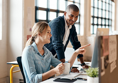 Buy stock photo Shot of a young businessman using a computer with his colleague in a modern office