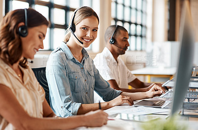 Buy stock photo Shot of a young woman using a headset and computer in a modern office