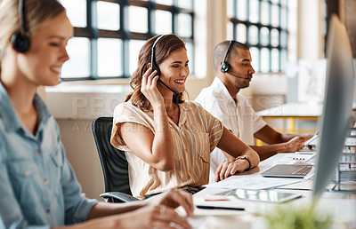 Buy stock photo Shot of a young woman using a headset and computer in a modern office