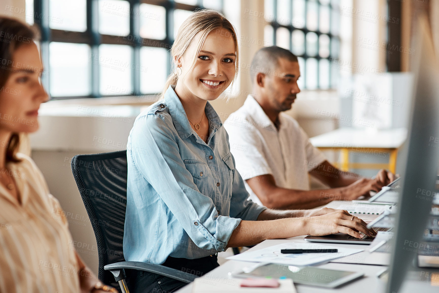 Buy stock photo Shot of a young businesswoman using a computer in a modern office