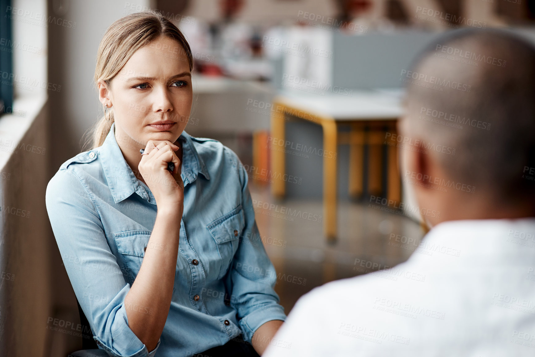 Buy stock photo Shot of a young businesswoman having a discussion with a colleague in a modern office