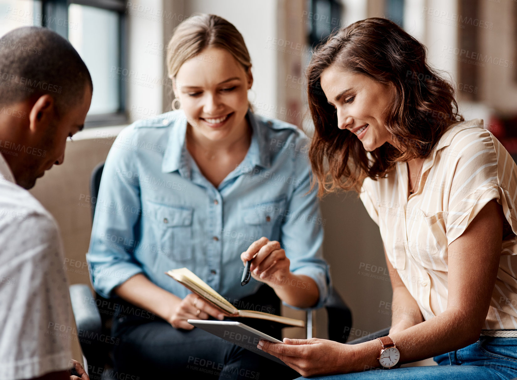 Buy stock photo Shot of a group of young businesspeople having a meeting in a modern office