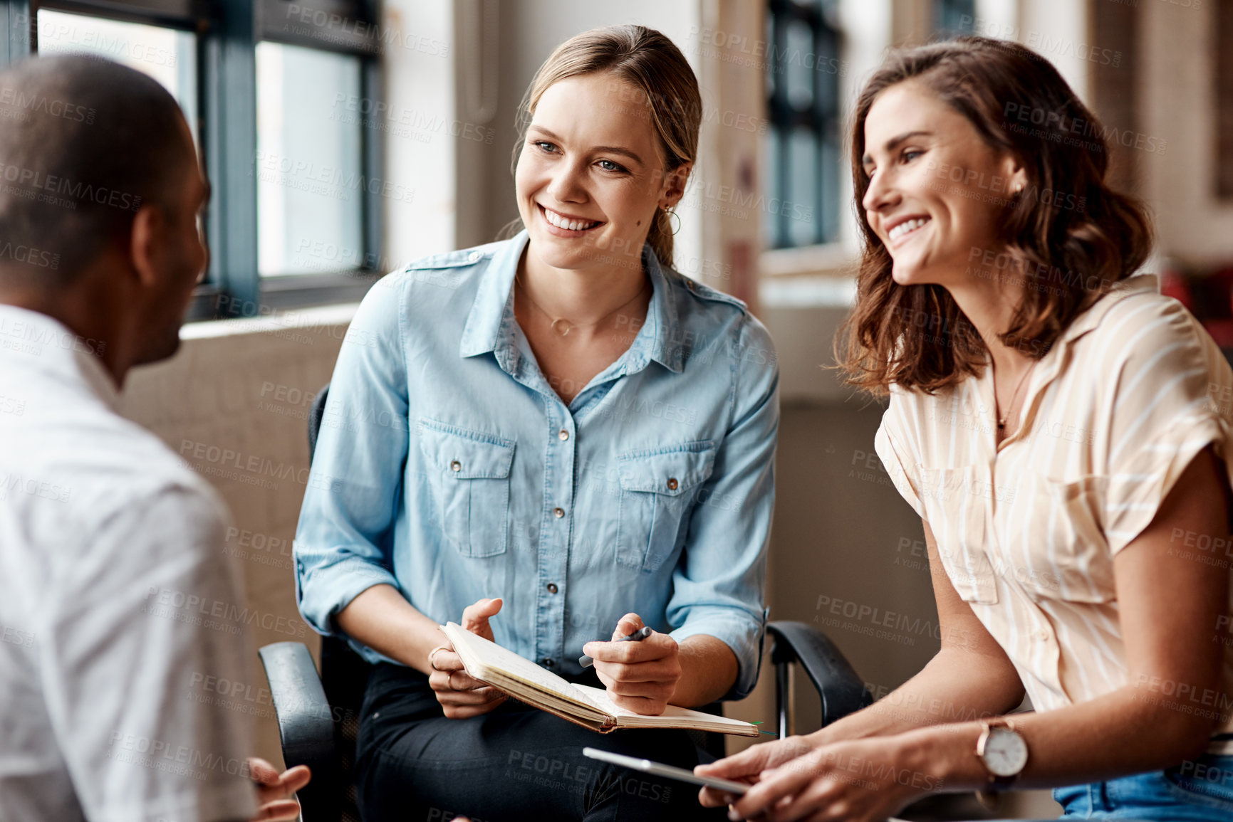 Buy stock photo Shot of a group of young businesspeople having a meeting in a modern office