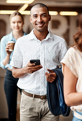 Buy stock photo Shot of a young businessman using a smartphone while waiting in line in a modern office