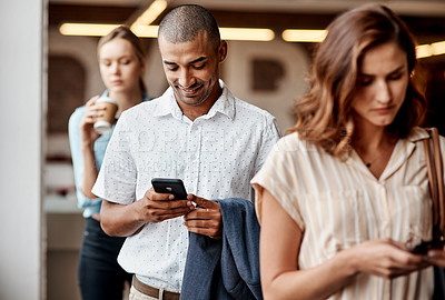 Buy stock photo Shot of a young businessman using a smartphone while waiting in line in a modern office