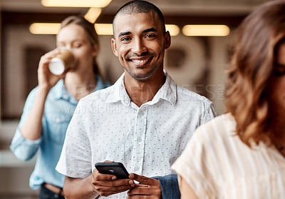 Buy stock photo Shot of a young businessman using a smartphone while waiting in line in a modern office