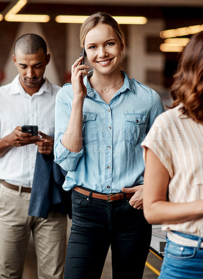 Buy stock photo Shot of a young businesswoman using a smartphone while waiting in line in a modern office