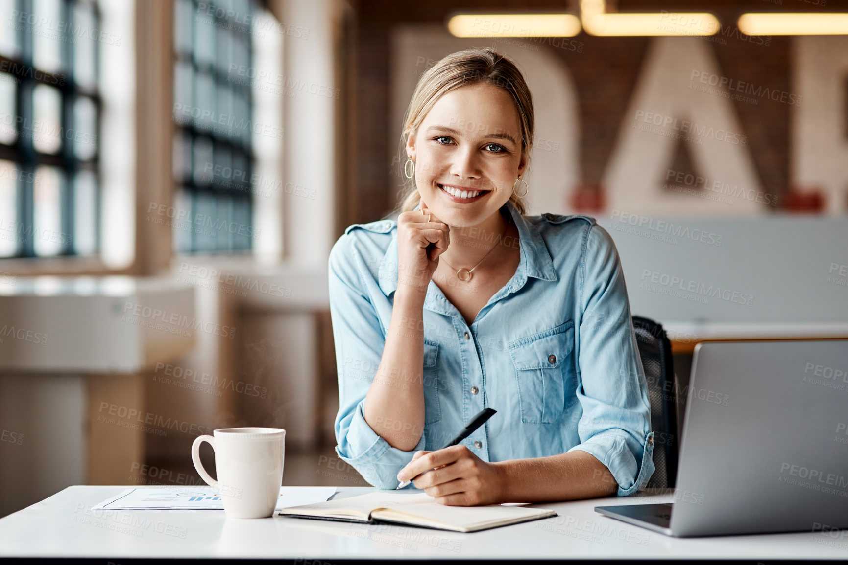 Buy stock photo Shot of a young businesswoman using a laptop in a modern office.