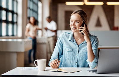 Buy stock photo Shot of a young businesswoman using a laptop, smartphone and making notes in a modern office