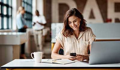 Buy stock photo Shot of a young businesswoman using a laptop and smartphone in a modern office
