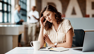 Buy stock photo Shot of a young businesswoman looking stressed out while using a laptop in a modern office