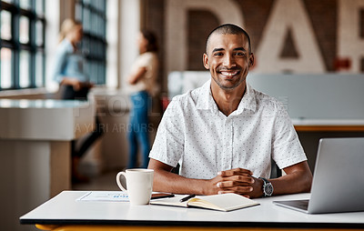 Buy stock photo Shot of a young businessman using a laptop in a modern office