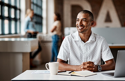 Buy stock photo Shot of a young businessman using a laptop in a modern office