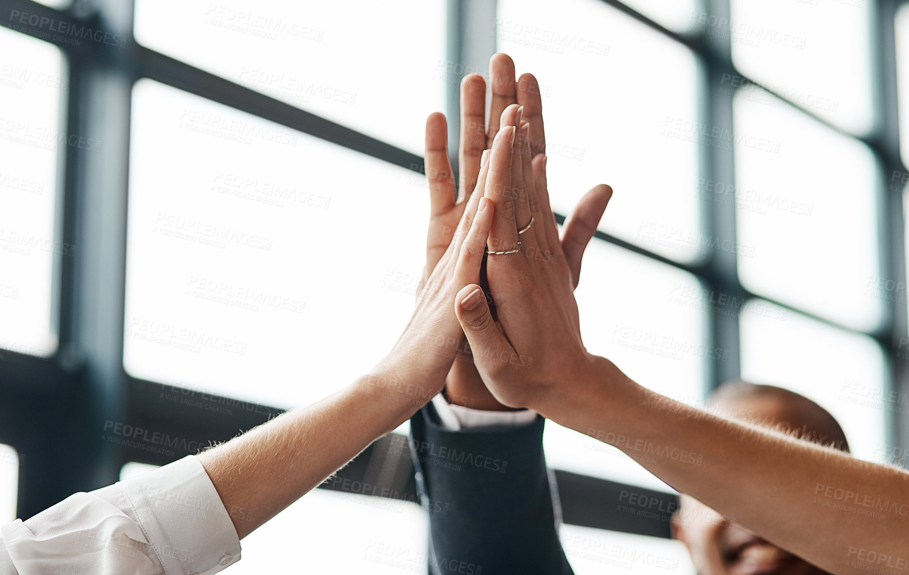 Buy stock photo Closeup shot of a group of unrecognisable businesspeople giving each other a high five in an office