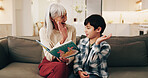 Book, grandmother or child with high five on sofa for literacy milestone, learning support or care. Family, boy or senior woman with celebration in home for reading goal, language development or love