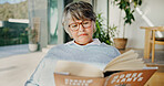 Senior, woman and reading with book in home for garden tips, story or natural growth. Elderly, female person or glasses with novel of house plants for eco friendly development, guide or knowledge