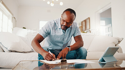 Buy stock photo Finance, documents and black man writing in home for budget planning, expenses or report. Mature person, tablet or paperwork with clipboard on sofa for financial assessment, bills or tax deductions