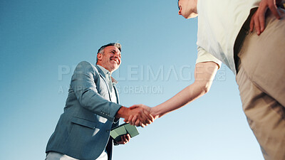 Buy stock photo Handshake, below and business men outdoor for negotiation, partnership and finance deal. Discussion, corporate and financial manager shaking hands with client for investment contract by blue sky.