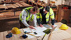 Documents, laptop and people in workshop for carpentry, wood production and planning with design. Carpenter, contractor and men on tech for inventory, furniture and blueprint for woodworking project