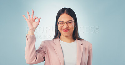 Buy stock photo Portrait, perfect and happy woman in studio for review or feedback on a blue background. Female person, glasses or smile with like emoji, yes or OK sign for business success, opinion or perfection
