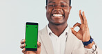 Portrait, phone and black man with green screen in studio for perfect app on a white background. Happy, businessman and smile with mobile smartphone display, ok sign or emoji for perfection on mockup