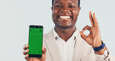 Buy stock photo Portrait, phone and black man with green screen in studio for perfect app on a white background. Happy, businessman and smile with mobile smartphone display, ok sign or emoji for perfection on mockup