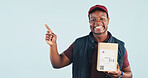 Pointing, portrait and delivery man in studio for shipping news, advertising or ecommerce info. Mockup, happy and African person with space for logistics, courier service and box on blue background