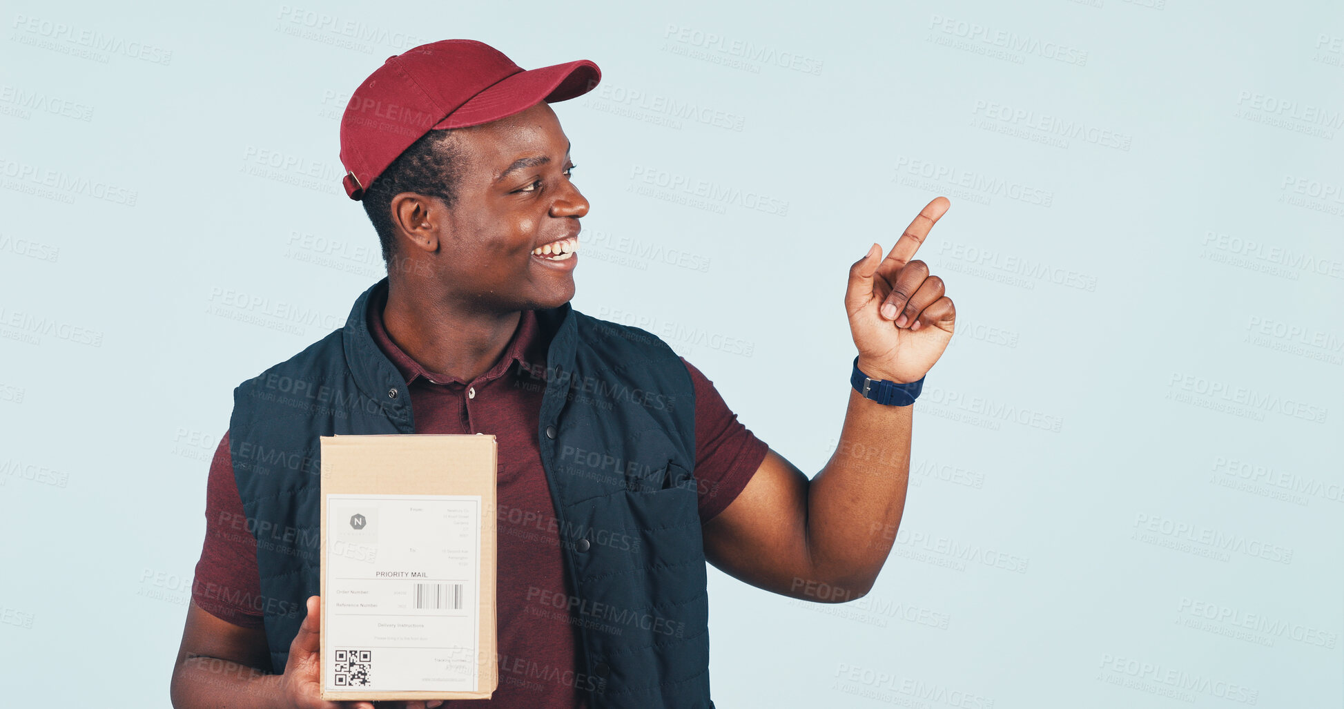 Buy stock photo Pointing, box and delivery man in studio for shipping news, advertising and ecommerce info. Mockup, happy and African person with gesture for logistics, courier service and space on blue background