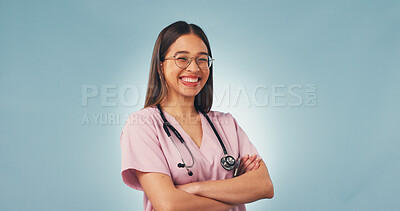 Buy stock photo Arms folded, woman or nurse in studio for healthcare, portrait or cancer care on blue background space. Happy female person, medical worker or oncology professional with confidence, pride or about us